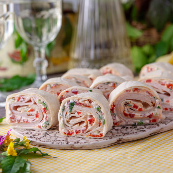 A picture of a platter of turkey tomato pinwheel sandwiches.
