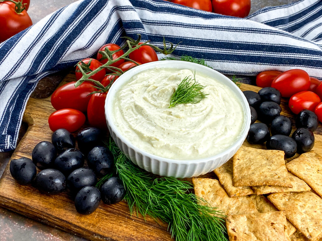 A picture of whipped feta dip surrounded by crackers and vegetables.