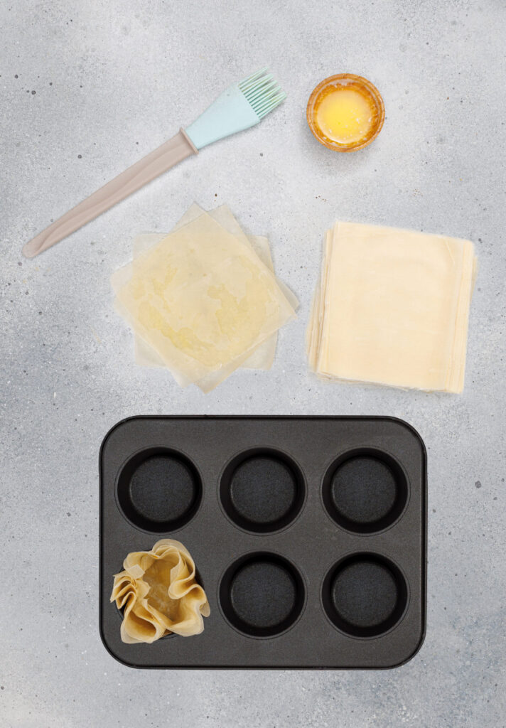 cut phyllo dough sheets into squares and bruch with butter